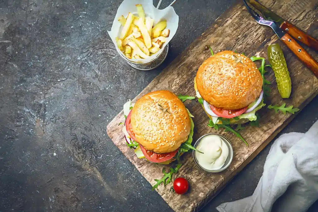 Burger and fries on a wooden slab.