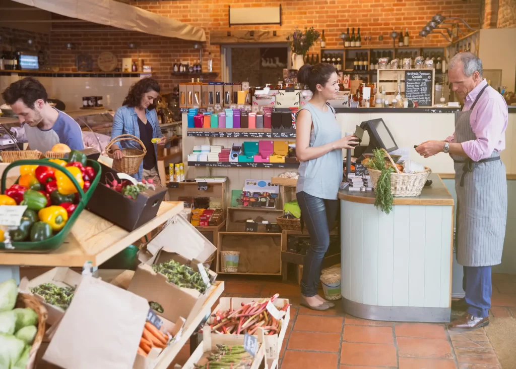 Woman at checking out at small local grocery store.