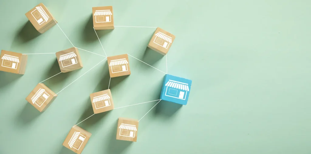 Franchise network concept shown with connected store icons on wooden blocks.