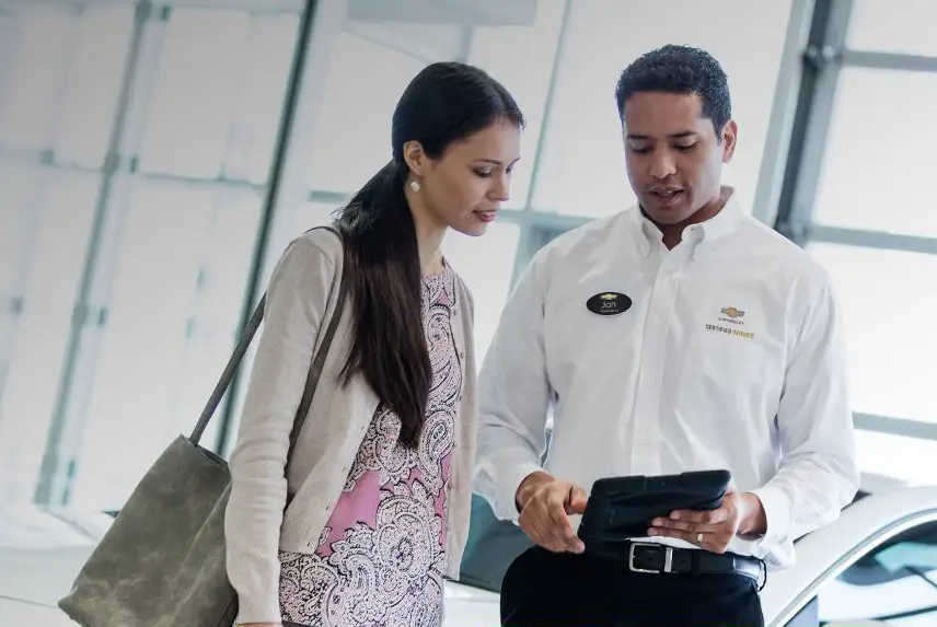Automotive service technician consultant going over service details with a client.